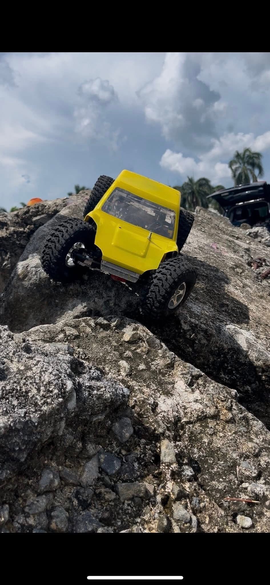 Yellow RC crawler scaling steep natural rock face at AYRC Talisay Bacolod
